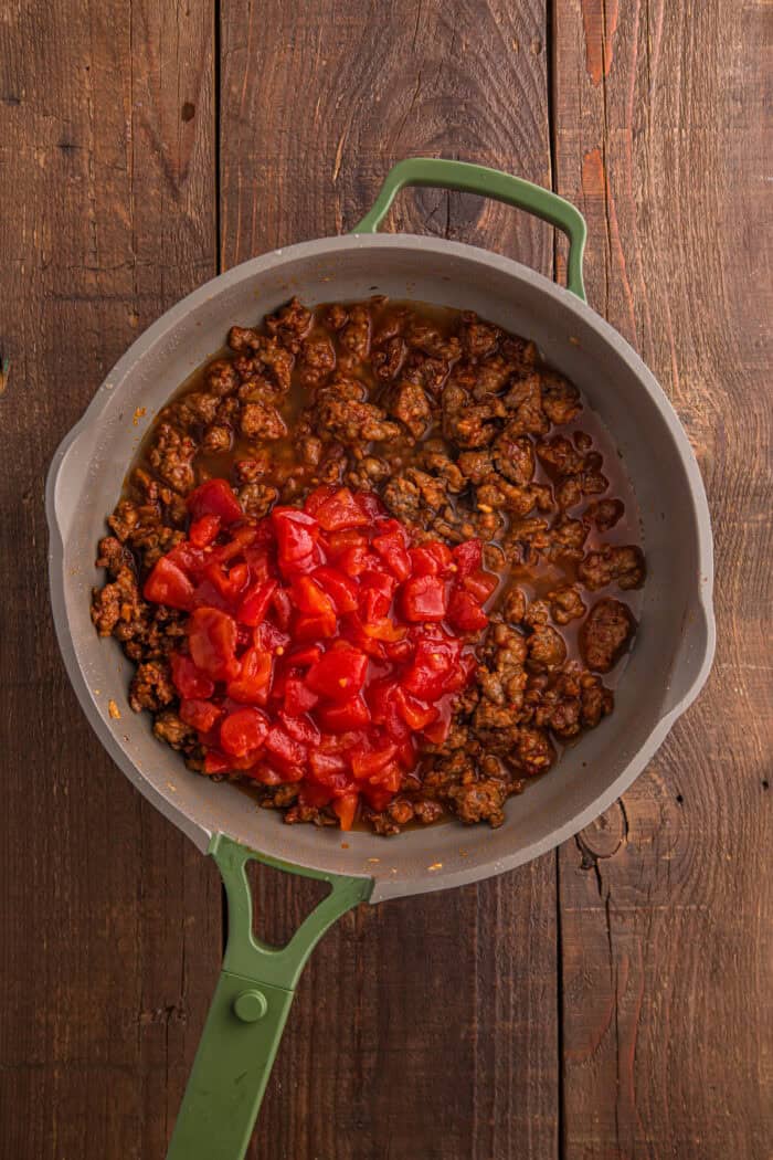 Italian Sausage Pasta is ready in just 30 minutes with a handful of ingredients. Creamy, decadent, and flavorful! Diced tomatoes added to Italian sausage in a pan