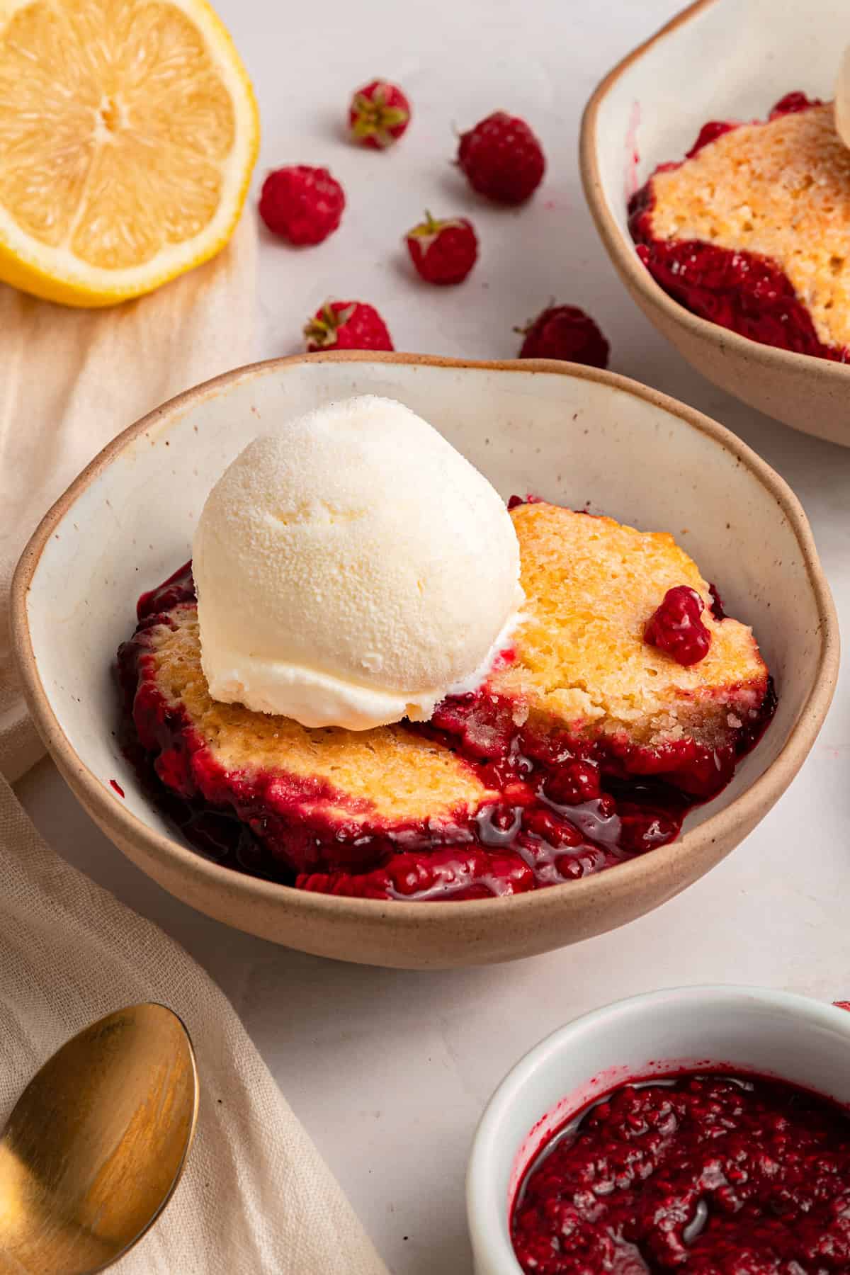 A bowl of raspberry cobbler with a scoop of ice cream