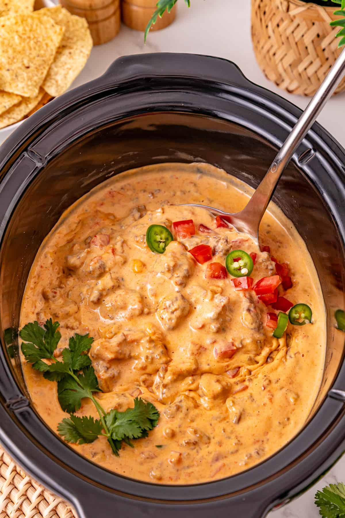 Cheesy Sausage Dip turns ground sausage, Velveeta, cream cheese, and Rotel into a creamy, cheesy, and irresistible party dip in just minutes. A spoon in crockpot sausage dip