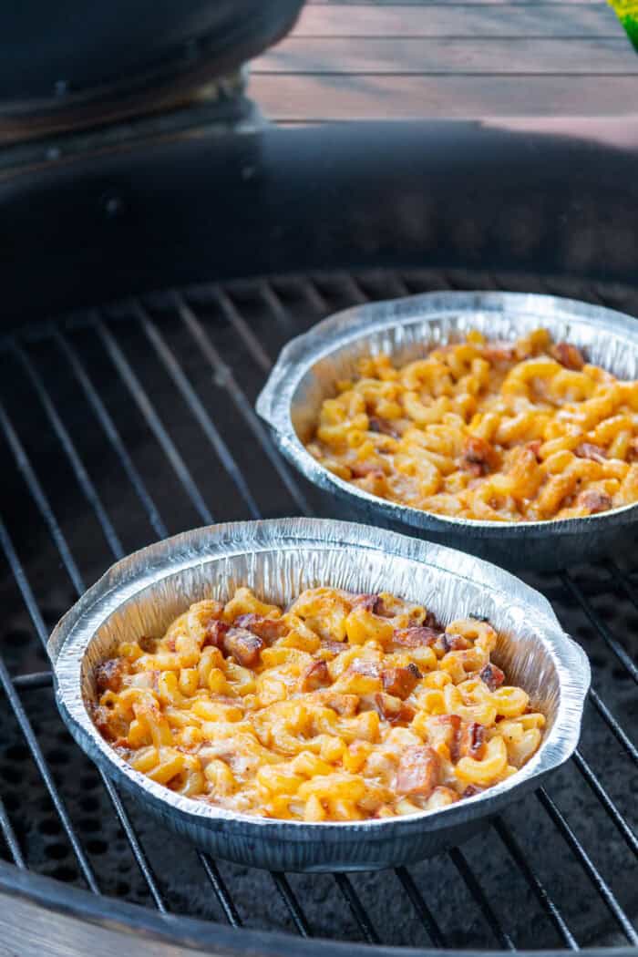 Macaroni and smoked sausage are tossed with a thick, creamy alfredo sauce base and lots of cheese to make this Easy Sausage Mac and Cheese. Two foil pans of campfire mac and cheese on the grill