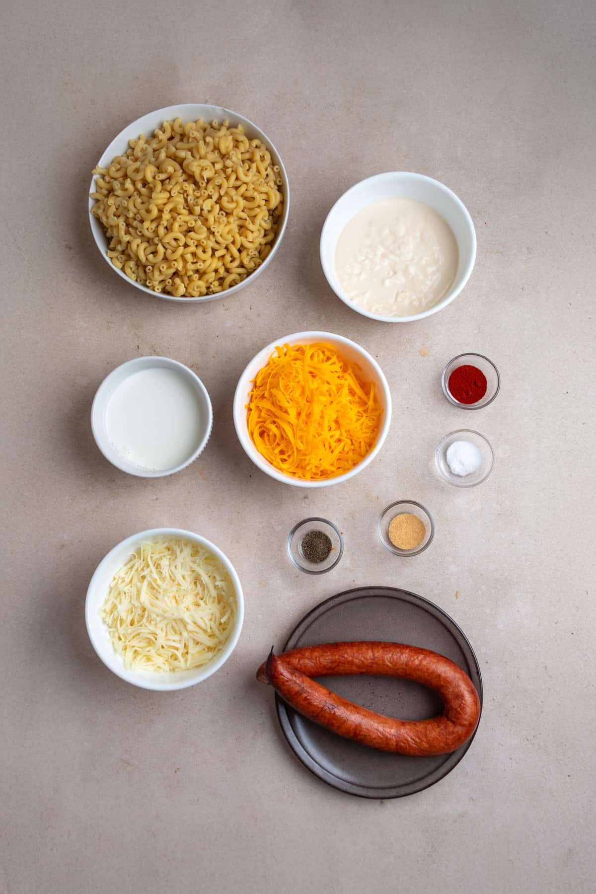 Macaroni and smoked sausage are tossed with a thick, creamy alfredo sauce base and lots of cheese to make this Easy Sausage Mac and Cheese. Overhead view of ingredients needed to make sausage mac and cheese