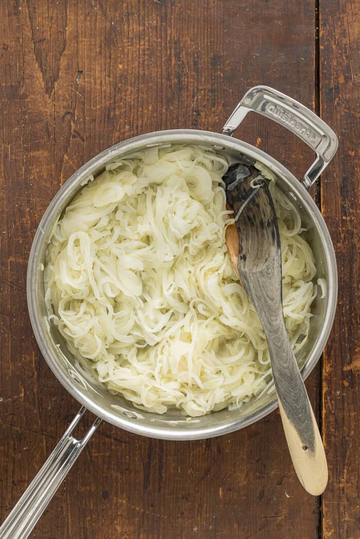 Sweet, savory caramelized onions are combined with tangy sour cream and cream cheese, plus a few seasonings, to make Caramelized Onion Dip. Sliced onions in a pan