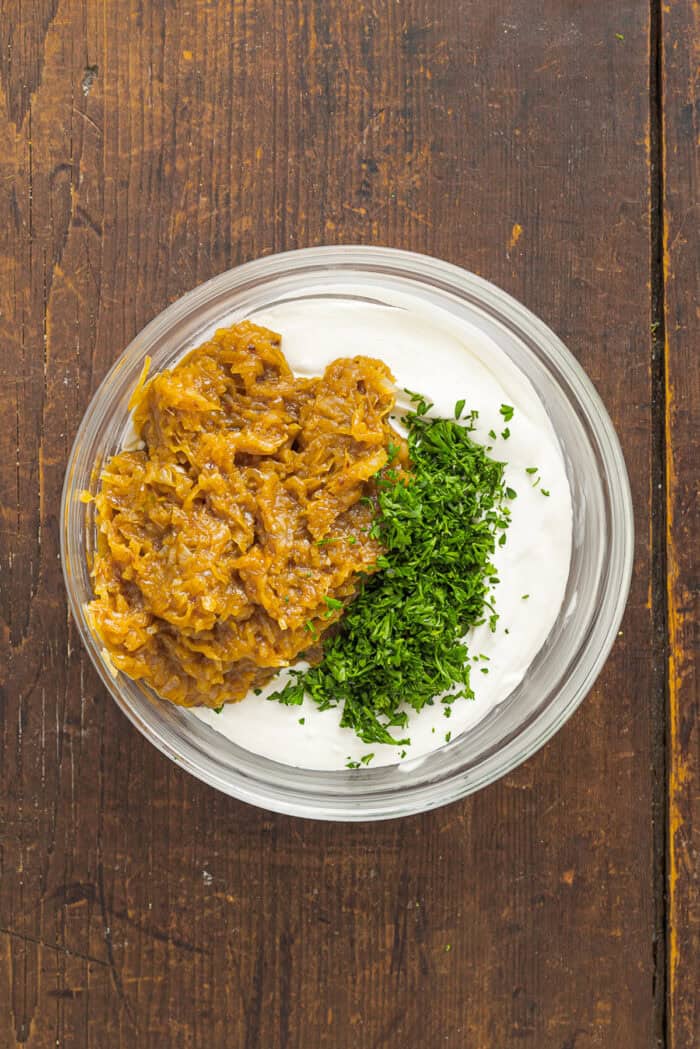 Sweet, savory caramelized onions are combined with tangy sour cream and cream cheese, plus a few seasonings, to make Caramelized Onion Dip. Caramelized onions and parsley added to sour cream and cream cheese