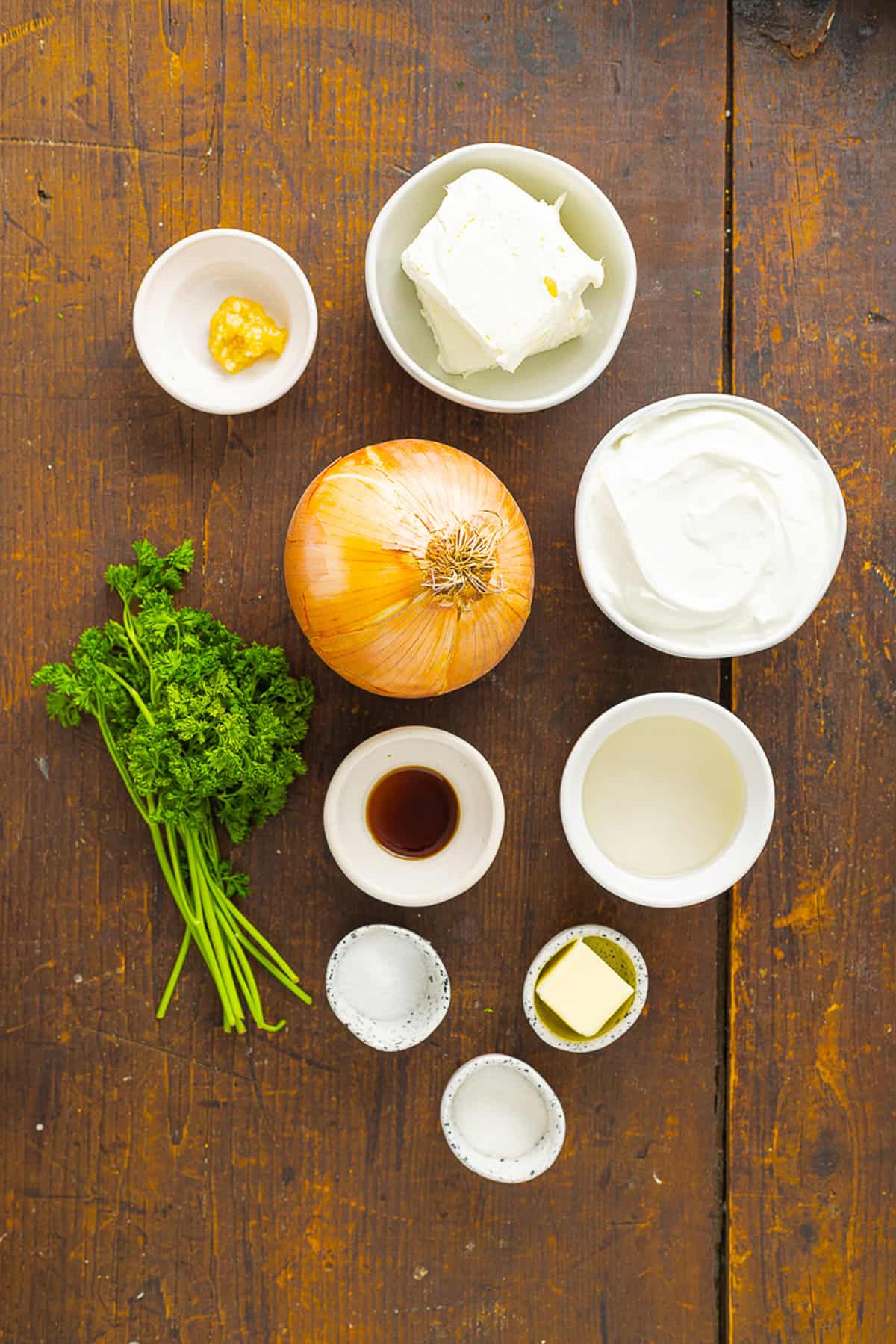Sweet, savory caramelized onions are combined with tangy sour cream and cream cheese, plus a few seasonings, to make Caramelized Onion Dip. Overhead view of ingredients needed to make caramelized onion dip
