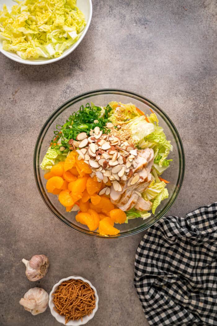 Grilled chicken, crunchy veggies, and mandarin oranges are tossed in a ginger sesame dressing in this easy Chinese Chicken Salad recipe. Lettuce, cabbage, green onions, carrots, oranges, and chicken in a bowl