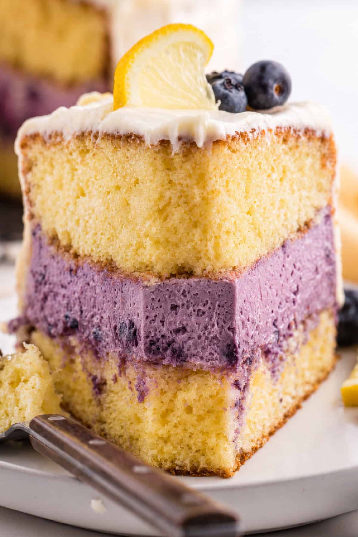 a bite taken from a lemon blueberry cheesecake cake slice