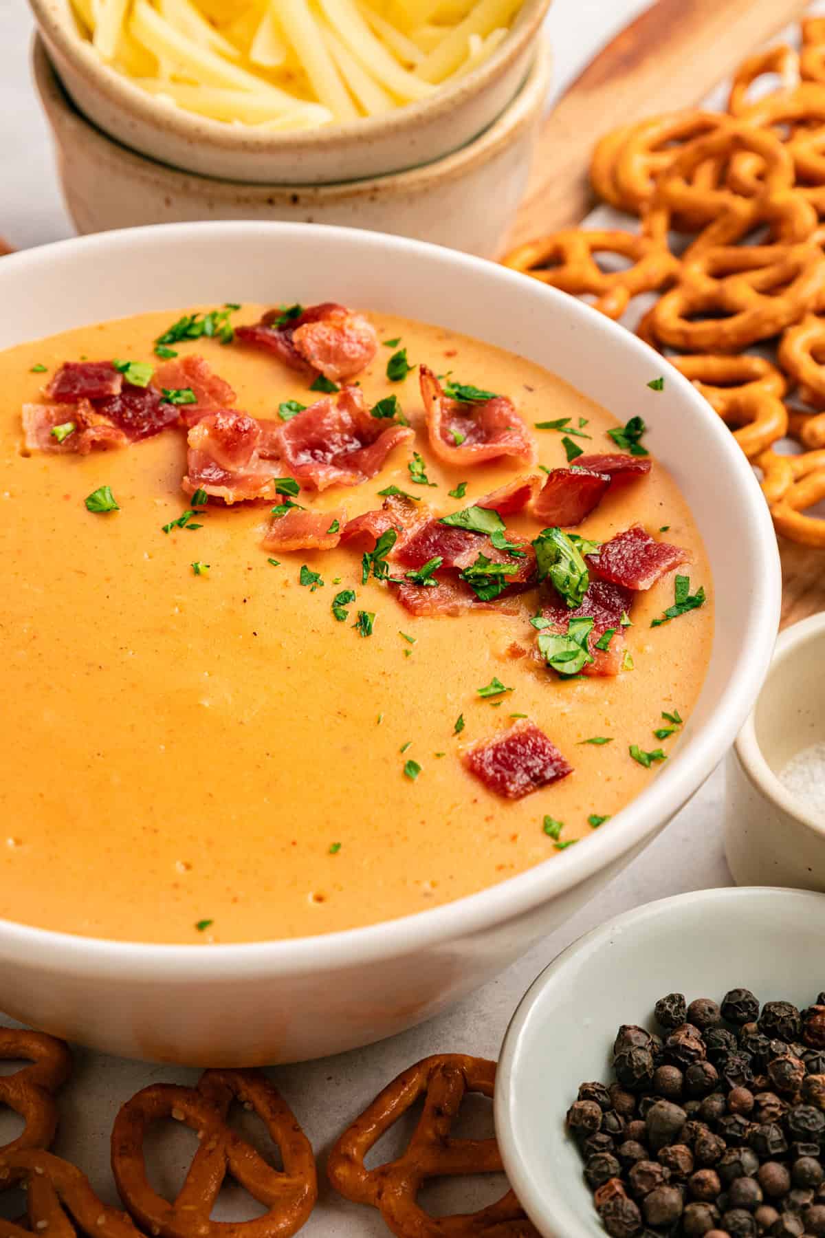 This Beer Cheese Dip is warm, sharp, and just a little smoky, with a combination of cheddar & gruyere and your favorite beer. Beer cheese dip in a white bowl