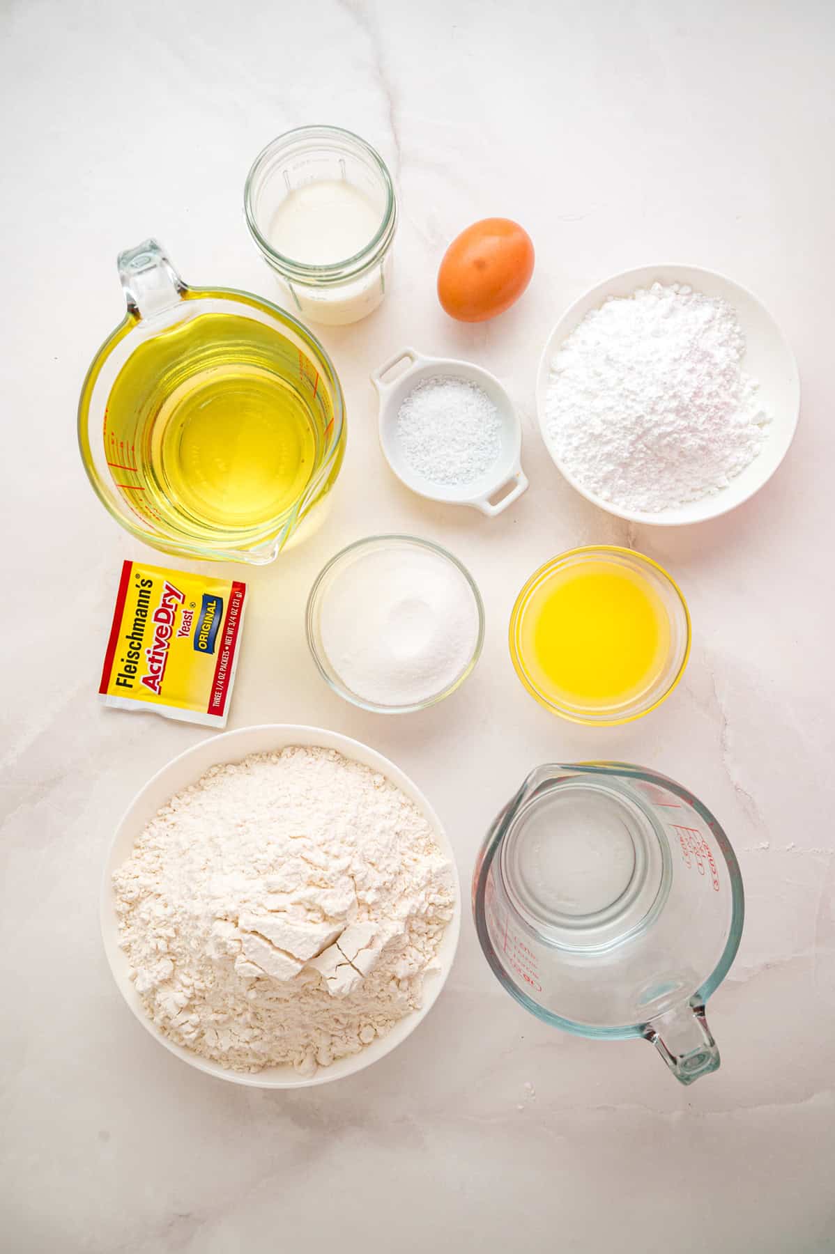 This Beignets recipe is an easy homemade version of the popular New Orleans fried square donuts. Soft & fluffy! Overhead view of ingredients needed to make beignets