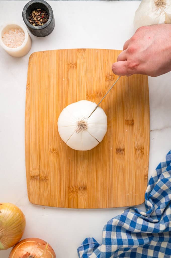 Onions are coated in a seasoned batter, then deep-fried to crispy, golden perfection in this Blooming Onion recipe. Cutting an onion on a cutting board