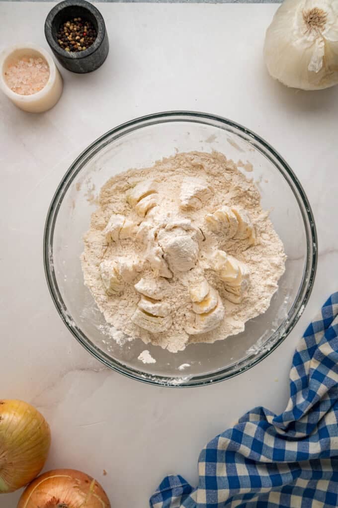 Onions are coated in a seasoned batter, then deep-fried to crispy, golden perfection in this Blooming Onion recipe. An onion coated in flour for the second time in a bowl