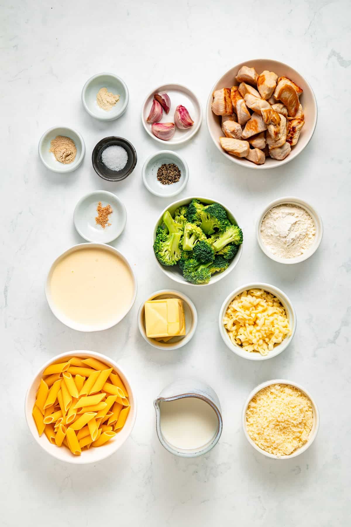 Tender penne, shredded chicken, and broccoli are tossed in a from-scratch sauce that's rich and garlicky in this Chicken Broccoli Alfredo. Overhead view of ingredients needed to make chicken and broccoli alfredo