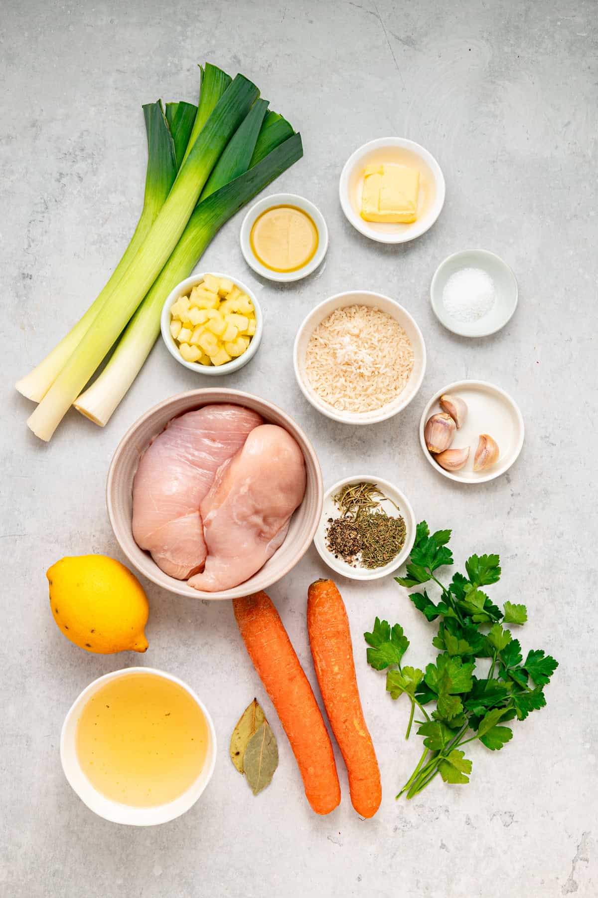 This Chicken and Leek Soup combines a buttery base of leeks, carrots and celery, tender shredded chicken, and long grain rice. Overhead view of ingredients needed to make chicken and leek soup