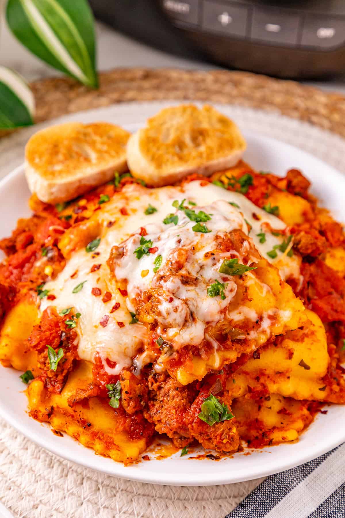 Ground beef with pasta sauce, frozen ravioli, and shredded cheese are layered to make this Crockpot Ravioli Lasagna. A plate of crockpot ravioli lasagna