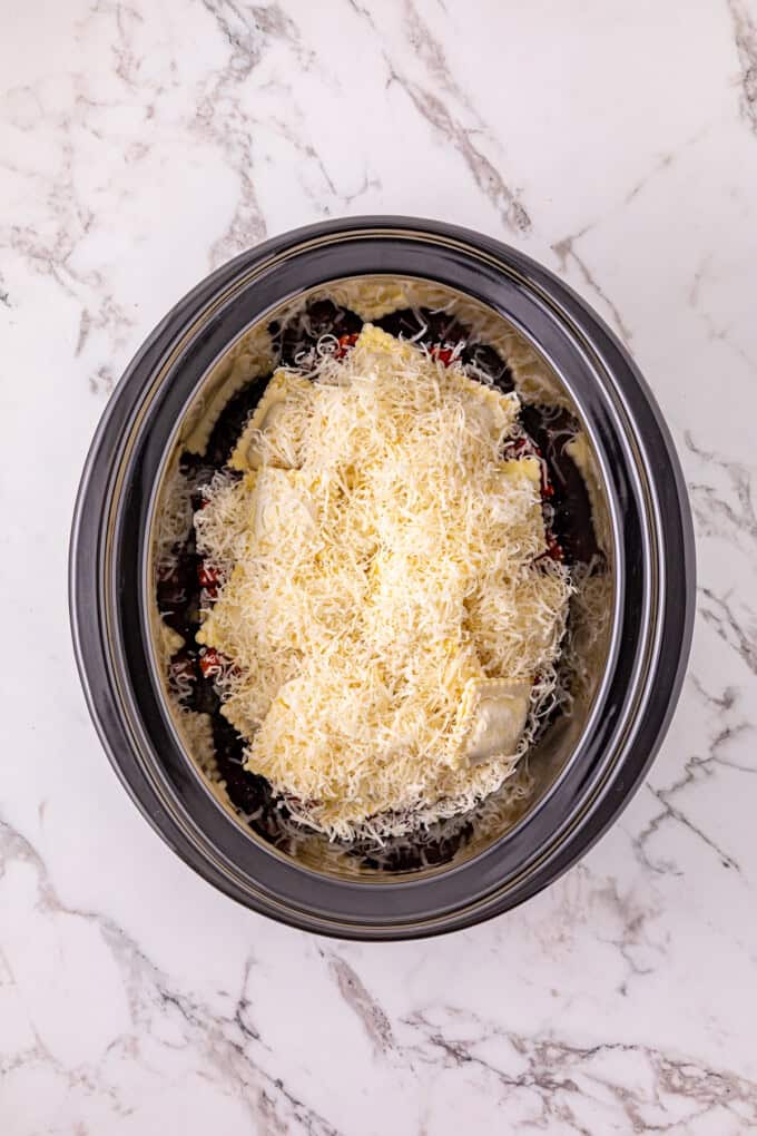 Ground beef with pasta sauce, frozen ravioli, and shredded cheese are layered to make this Crockpot Ravioli Lasagna. Cheese on top of raviolis in the crockpot