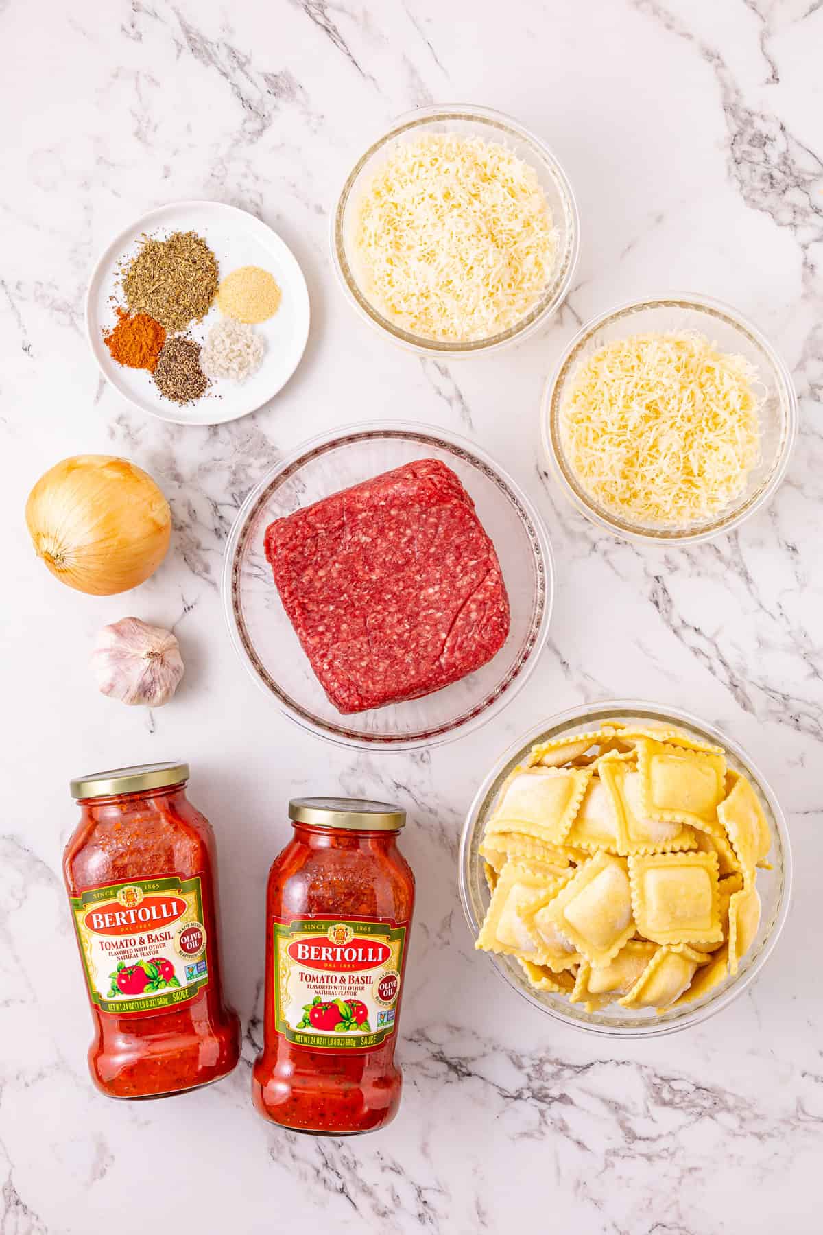 Ground beef with pasta sauce, frozen ravioli, and shredded cheese are layered to make this Crockpot Ravioli Lasagna. Overhead view of ingredients needed to make crockpot ravioli lasagna