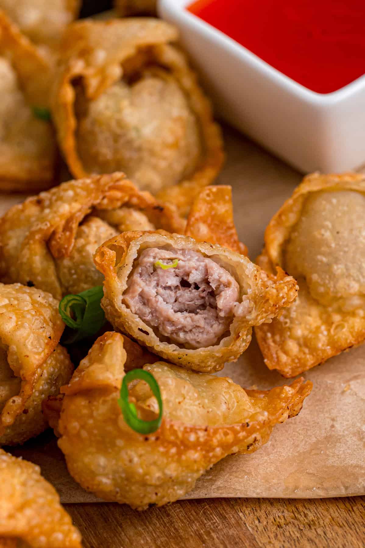With a savory ground pork filling and crispy golden outside, this Fried Wonton recipe brings Chinese takeout to the table in 30 minutes. Close up of fried wontons, one open to show the inside