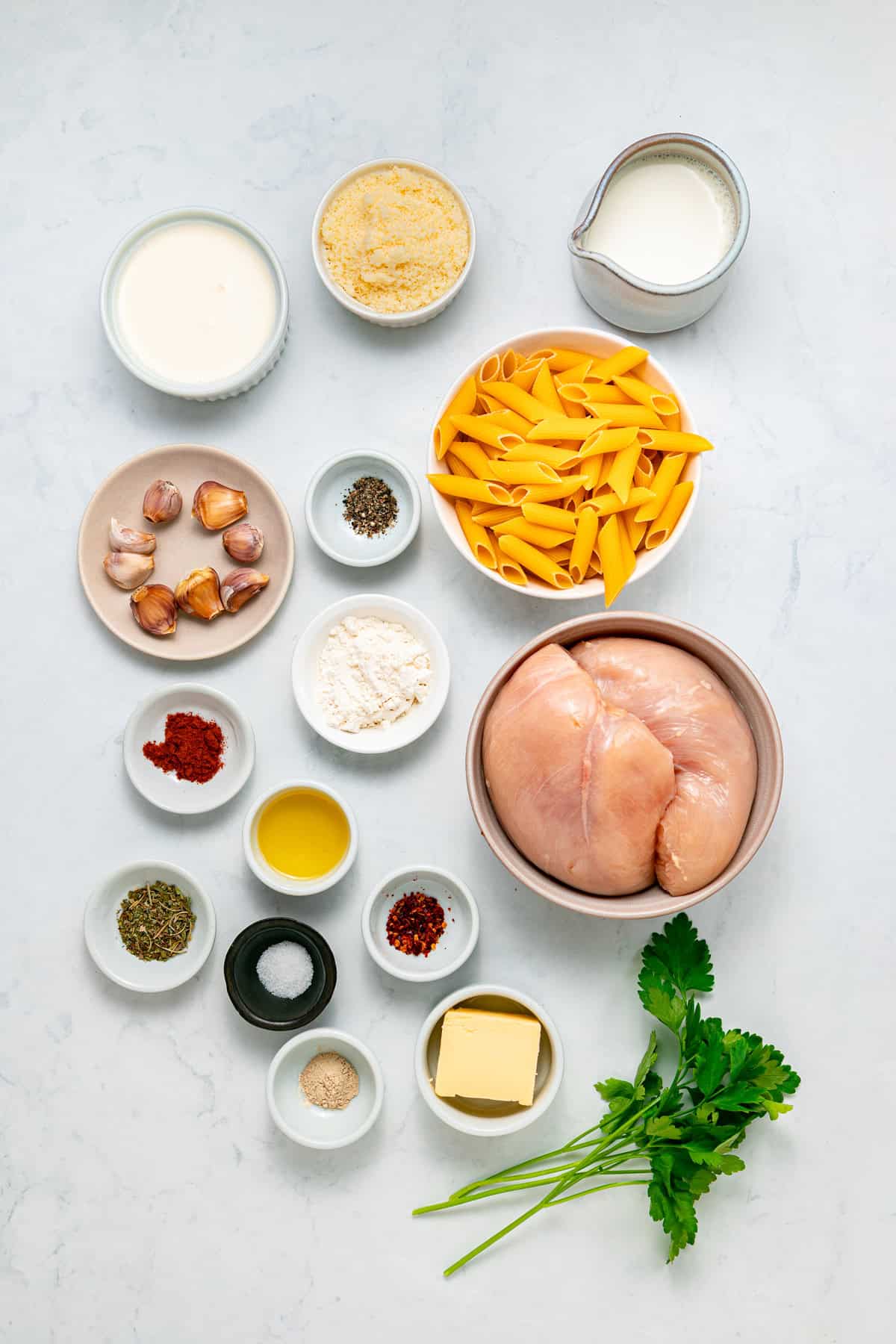 With tender, juicy chicken coated in a creamy garlic sauce, this Garlic Parmesan Chicken Pasta is an easy weeknight dinner. Overhead view of ingredients needed to make garlic parmesan chicken pasta