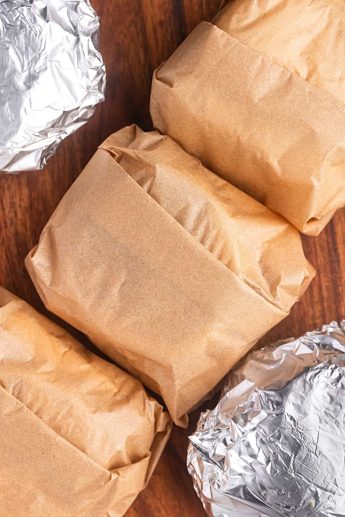 Made with English muffins, sheet pan eggs, cheese, and meat, these Make Ahead Breakfast Sandwiches are perfect for busy mornings! Make ahead breakfast sandwiches wrapped in parchment paper and foil