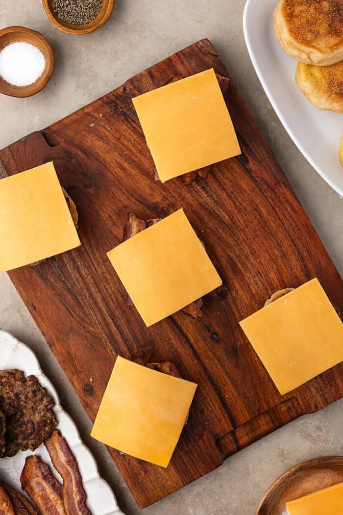 Made with English muffins, sheet pan eggs, cheese, and meat, these Make Ahead Breakfast Sandwiches are perfect for busy mornings! English muffin halves topped with eggs and a slice of cheese