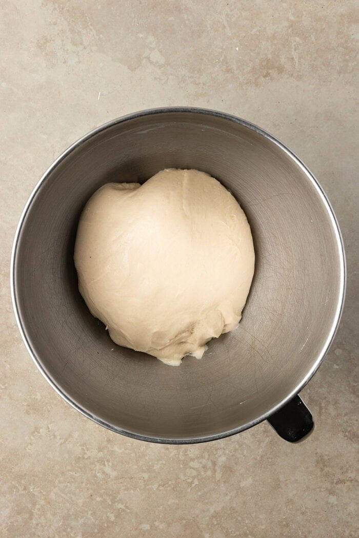 These Sourdough English Muffins are soft, chewy, and full of the classic nooks and crannies everyone loves. A ball of dough in a mixing bowl