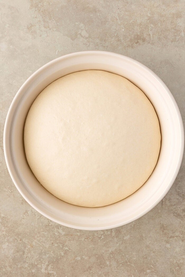These Sourdough English Muffins are soft, chewy, and full of the classic nooks and crannies everyone loves. Dough in a bowl after proofing