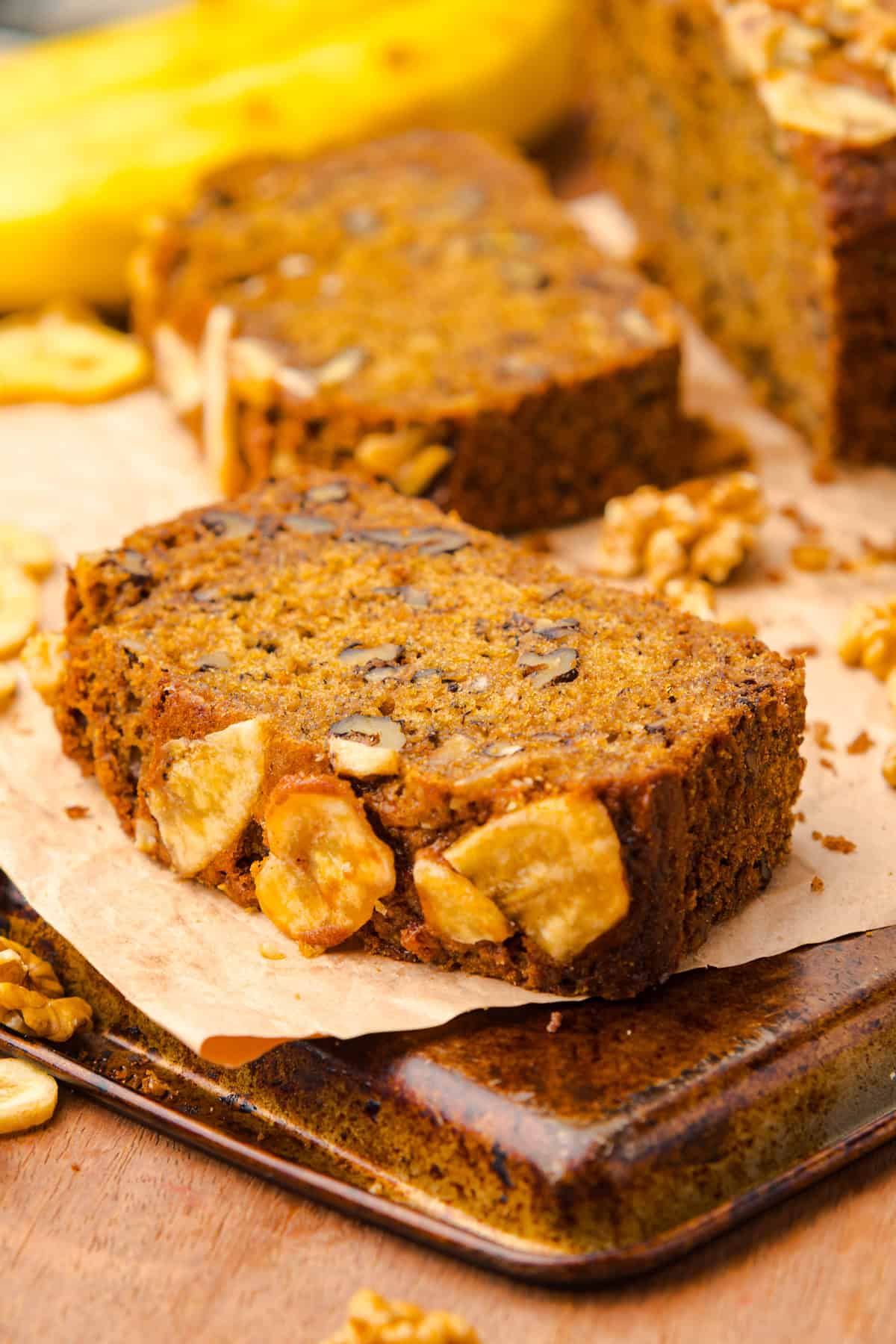 This copycat Starbucks Banana Bread is soft and moist, with lots of sweet banana flavor and warm spices. One bowl + 15 minutes! A slice of Starbucks banana bread on a cutting board