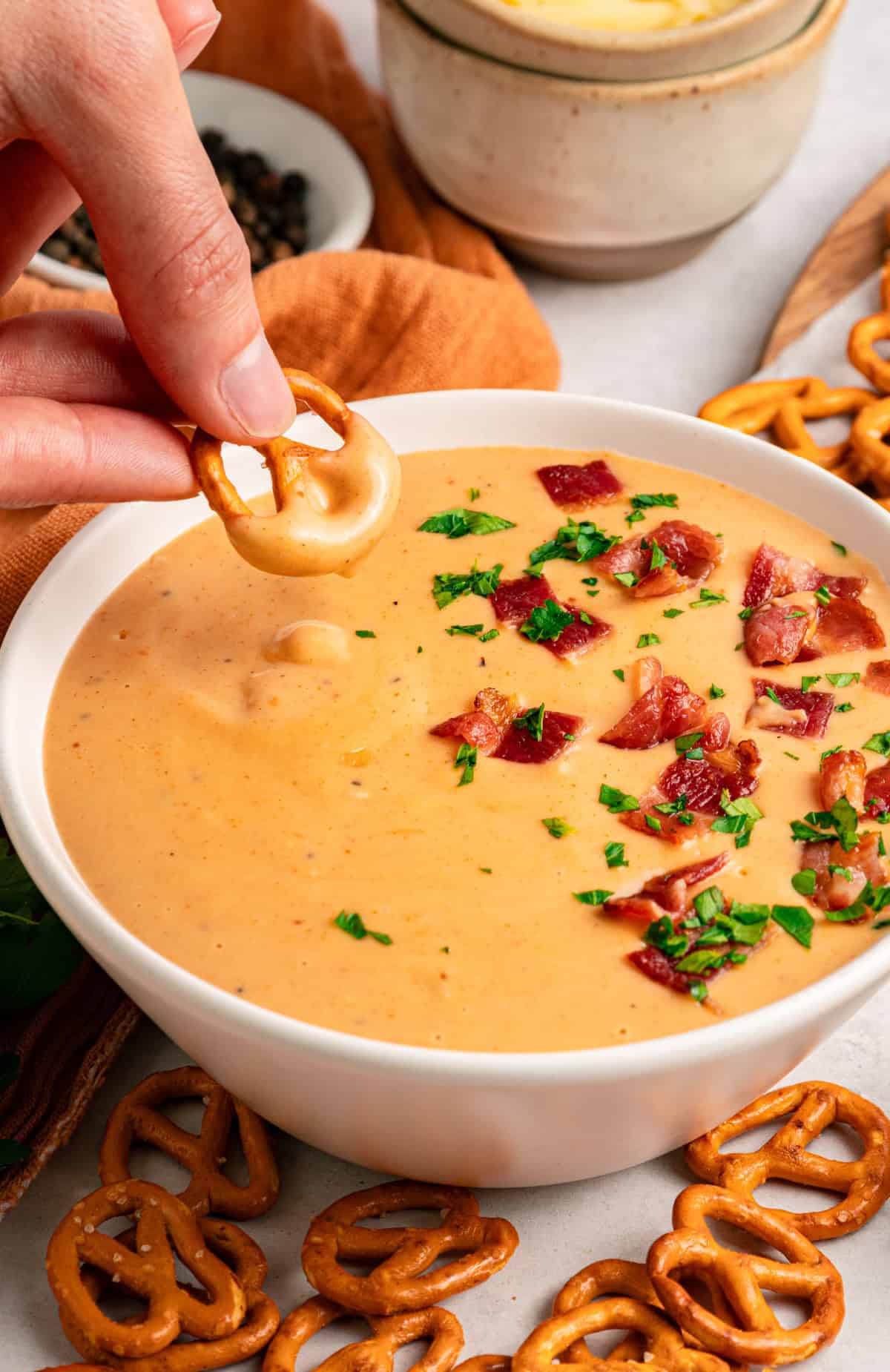 This Beer Cheese Dip is warm, sharp, and just a little smoky, with a combination of cheddar & gruyere and your favorite beer. a pretzel with Beer Cheese Dip on it
