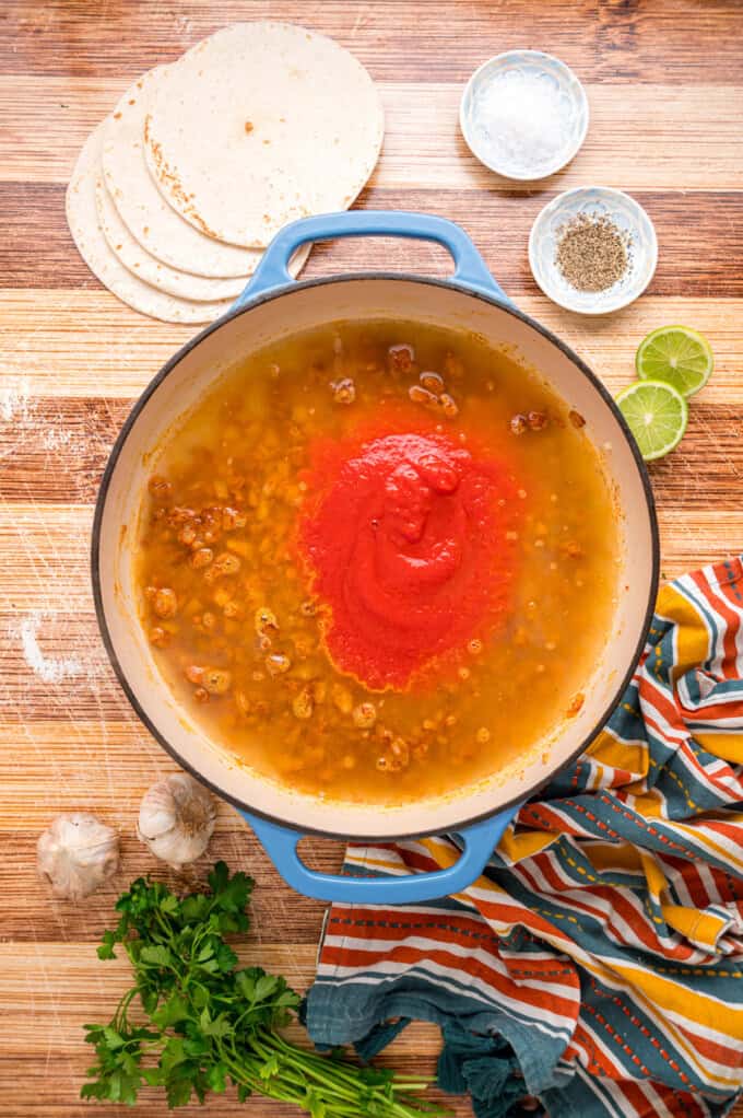 With layers of tortillas, enchilada sauce, gooey cheese, and chicken and beans, Chicken Enchilada Casserole is an easy weeknight dinner. Chicken broth and tomato sauce added to the onions