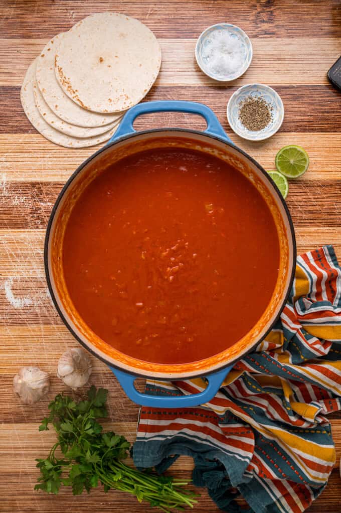 With layers of tortillas, enchilada sauce, gooey cheese, and chicken and beans, Chicken Enchilada Casserole is an easy weeknight dinner. A pot of enchilada sauce