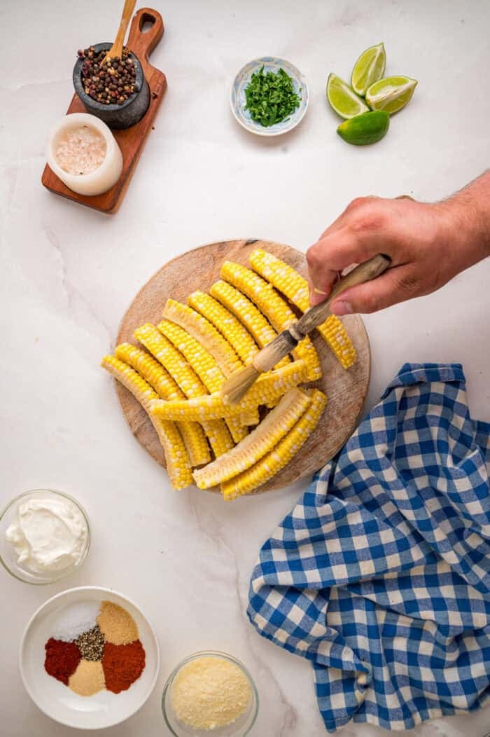 These easy Corn Ribs are coated in warm, smoky spices, cooked in the air fryer or grill, drizzled with lime crema. Brushing corn ribs with butter and oil