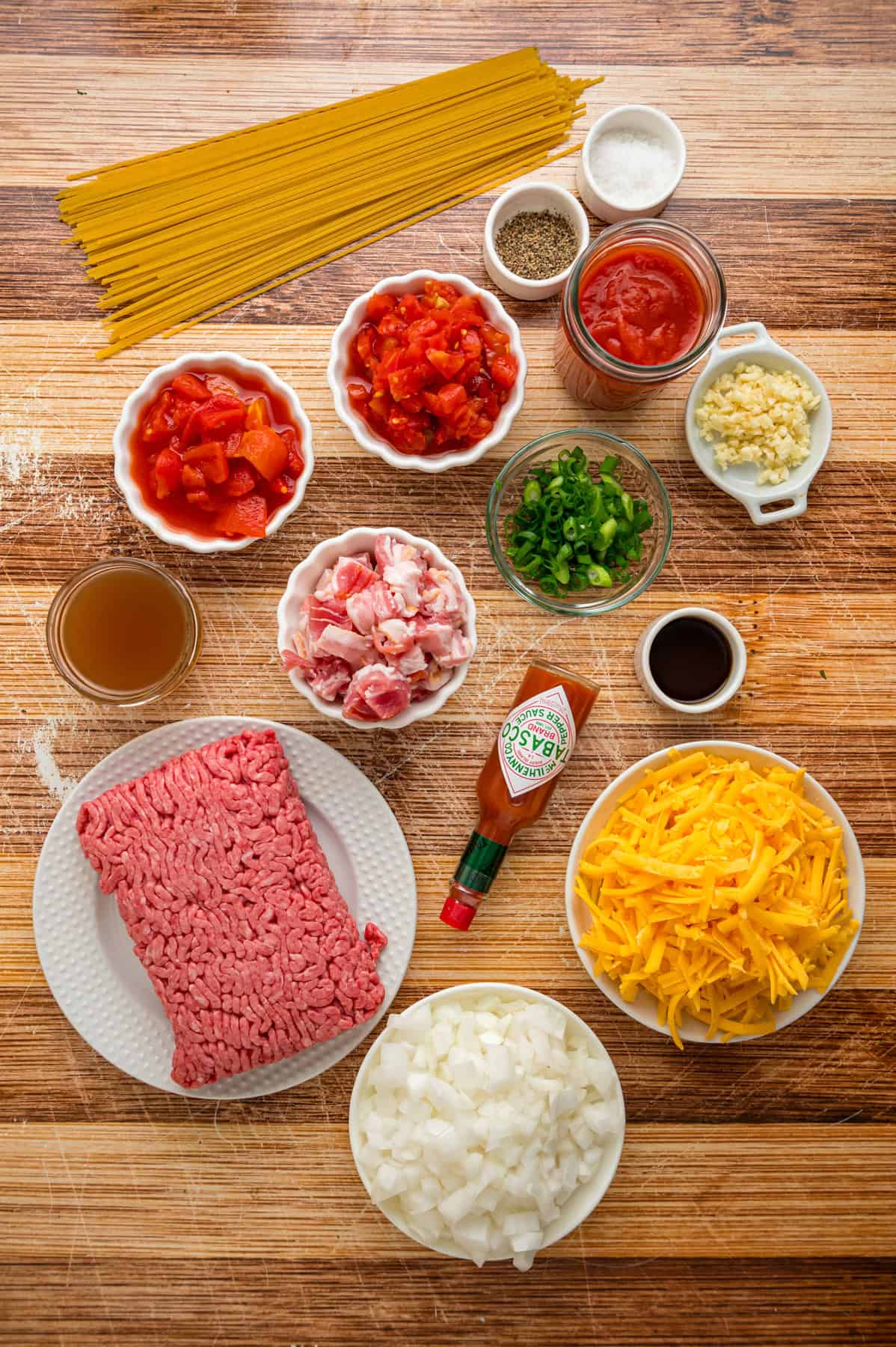 Cowboy Spaghetti is an extra hearty and flavorful take on classic spaghetti, with ground beef, bacon, tomatoes and green chilies, and cheese. Overhead view of ingredients needed to make cowboy spaghetti