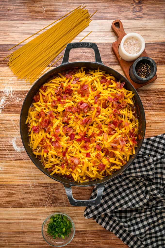 Cowboy Spaghetti is an extra hearty and flavorful take on classic spaghetti, with ground beef, bacon, tomatoes and green chilies, and cheese. Bacon crumbled on top of the cheese