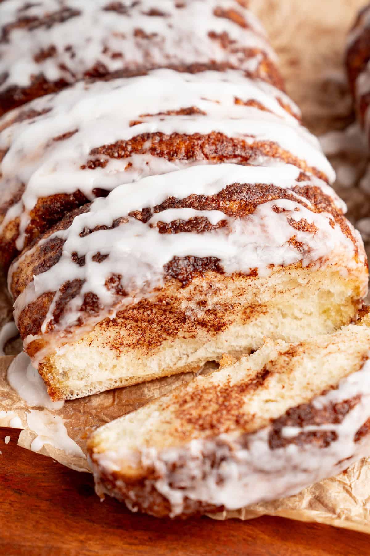This Dollywood Cinnamon Bread copycat recipe has a buttery, caramelized cinnamon-sugar coating and sweet glaze drizzled over the top. Dollywood cinnamon bread loaf opened to show the soft inside.