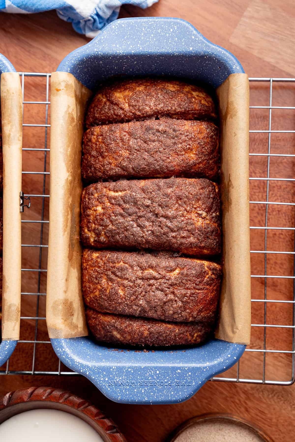 This Dollywood Cinnamon Bread copycat recipe has a buttery, caramelized cinnamon-sugar coating and sweet glaze drizzled over the top. baked dollywood cinnamon bread in a pan
