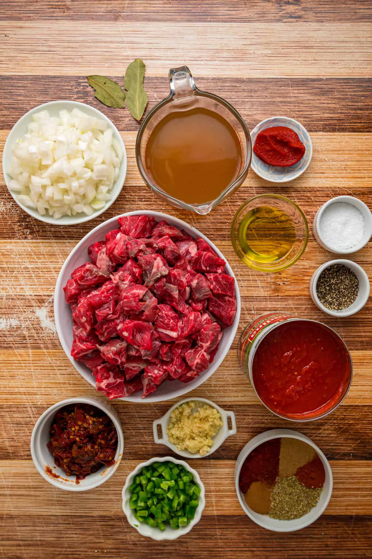 Seared chunks of chuck roast are simmered with crushed tomatoes, jalapenos, and chipotles in adobo sauce to make this Texas Chili recipe. Overhead view of ingredients needed to make Texas chili