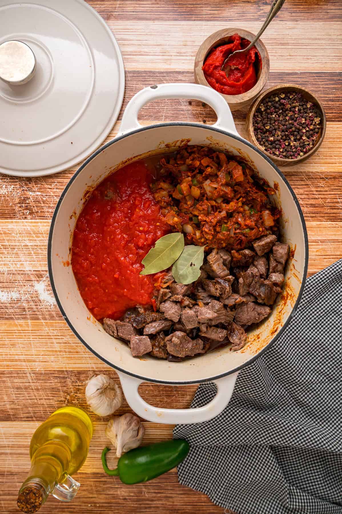 Tomato paste and tomatoes added to the pot