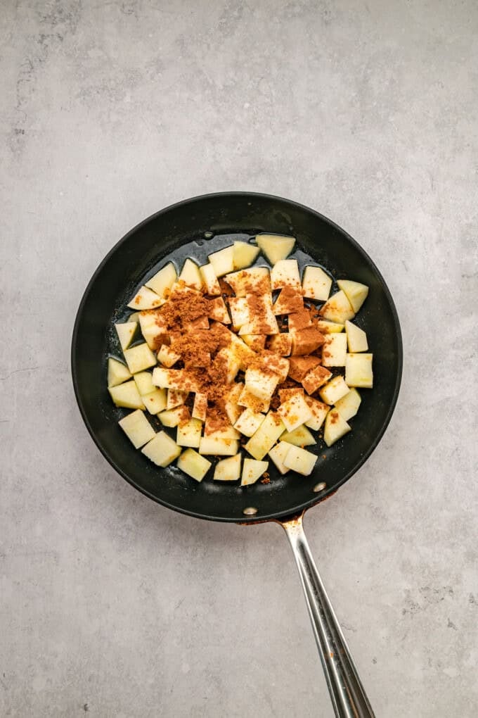 With tender, caramelized apples and lightly spiced maple syrup oats, this Baked Apple Oatmeal is the perfect fall breakfast. Diced apples and spices in a pan