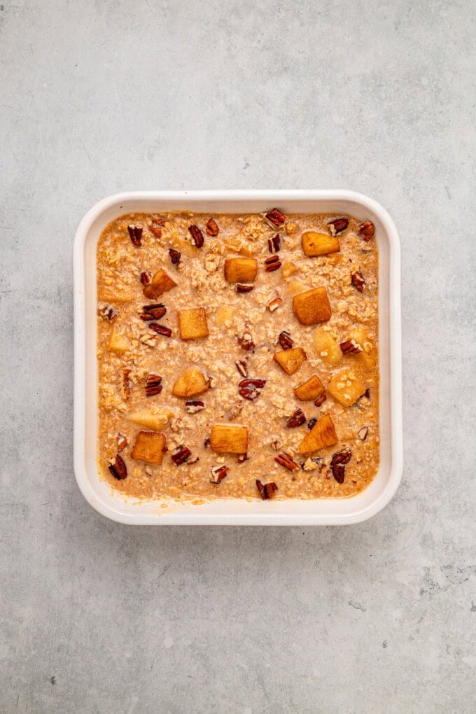 With tender, caramelized apples and lightly spiced maple syrup oats, this Baked Apple Oatmeal is the perfect fall breakfast. Unbaked apple oatmeal in a baking dish