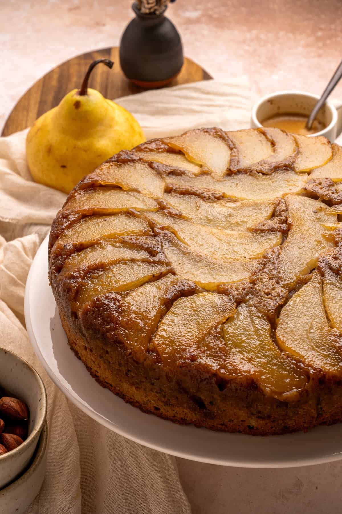 With a moist and tender cake topped with soft caramelized pears, this Pear Upside Down Cake is perfect for fall. Pear upside down cake on a white plate