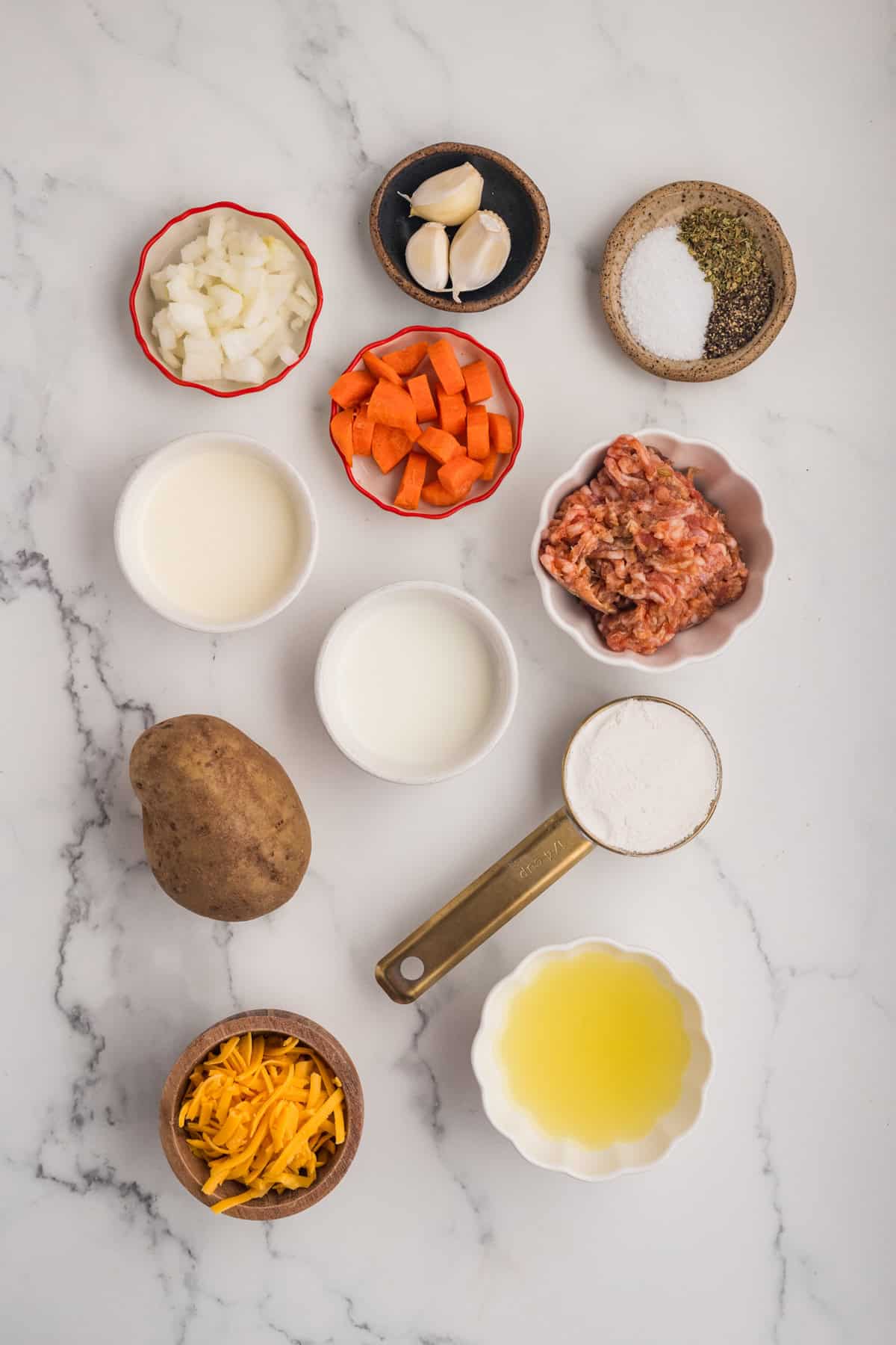This Sausage Potato Soup is rich, creamy, and loaded with savory Italian sausage, tender potatoes, sweet carrots, and sharp cheddar cheese. Overhead view of ingredients needed to make sausage potato soup