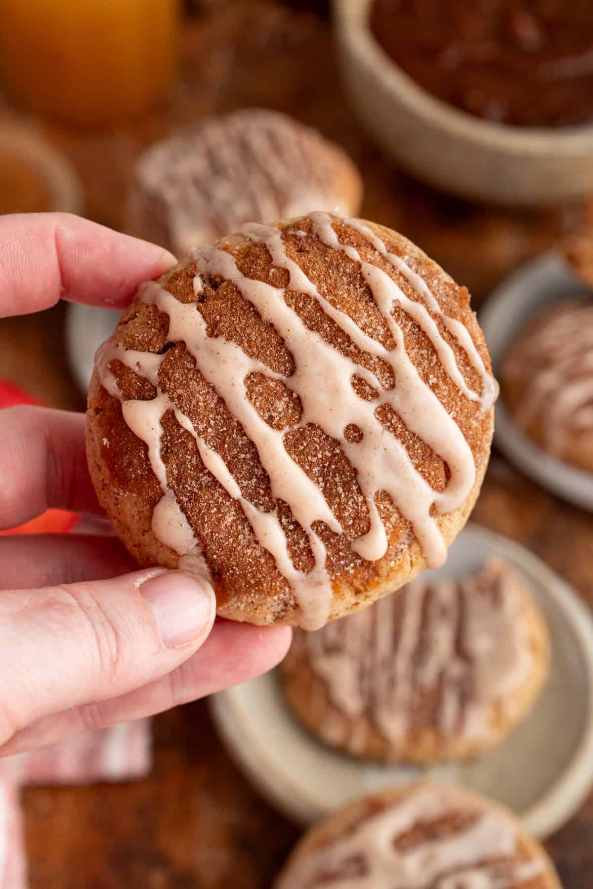 These Apple Cider Cookies are soft and chewy with plenty of warm fall flavor. a hand holding a freshly baked apple cider cookie.