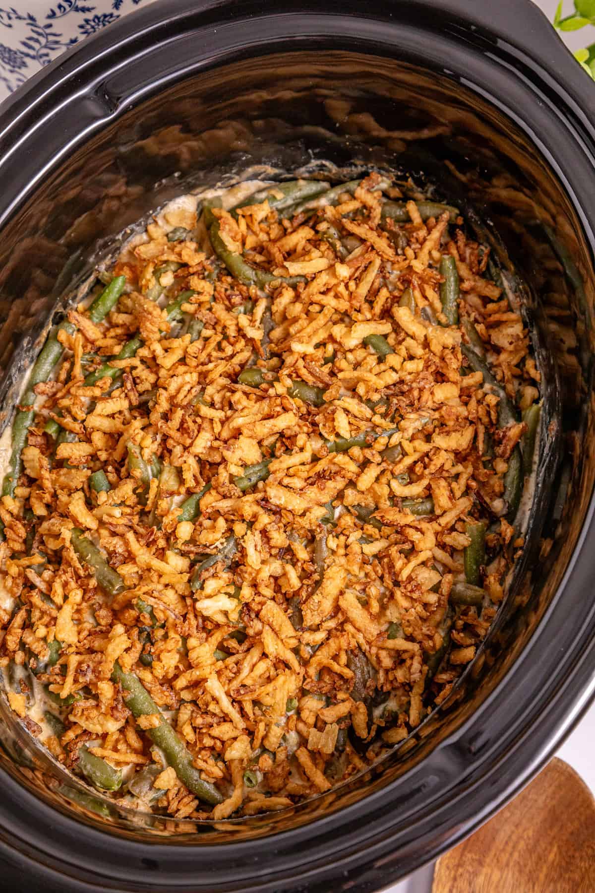 This Slow Cooker Green Bean Casserole is the perfect hands-off side dish for the holidays! Made with just a few ingredients. Overhead view of green bean casserole in the slow cooker