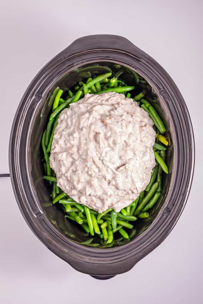 This Slow Cooker Green Bean Casserole is the perfect hands-off side dish for the holidays! Made with just a few ingredients. Cream of mushroom mixture on top of green beans