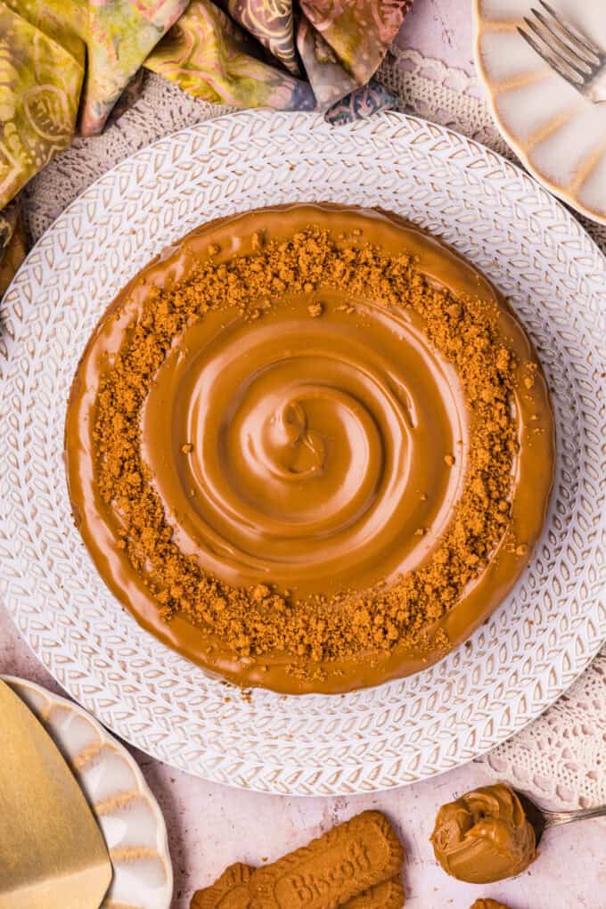 A creamy cookie butter cheesecake filling is baked in a Biscoff crust and topped with more cookie butter in this Biscoff Cheesecake recipe. Overhead view of a Biscoff cheesecake