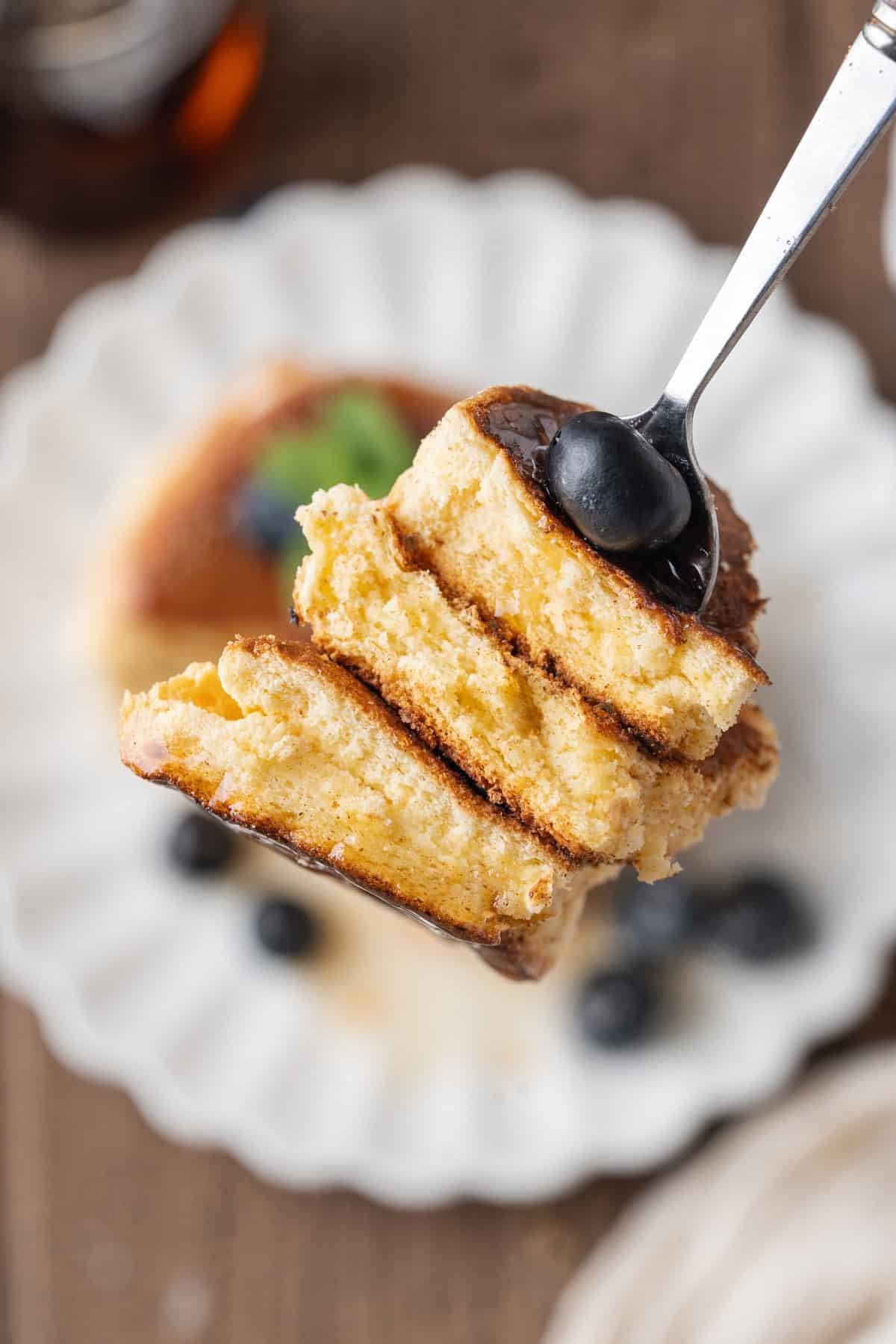 These Japanese Soufflé Pancakes are tall, fluffy, jiggly, and unbelievably soft, thanks to the meringue in the batter. A bite of Japanese souffle pancakes on a fork