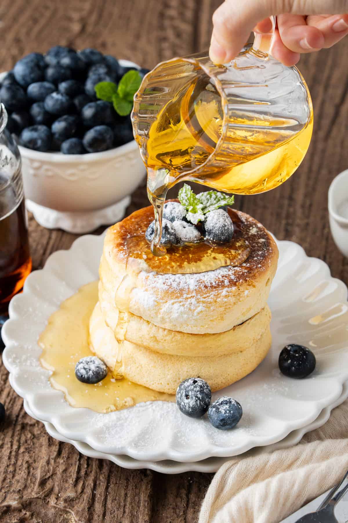 These Japanese Soufflé Pancakes are tall, fluffy, jiggly, and unbelievably soft, thanks to the meringue in the batter. Drizzling honey over a plate of Japanese souffle pancakes