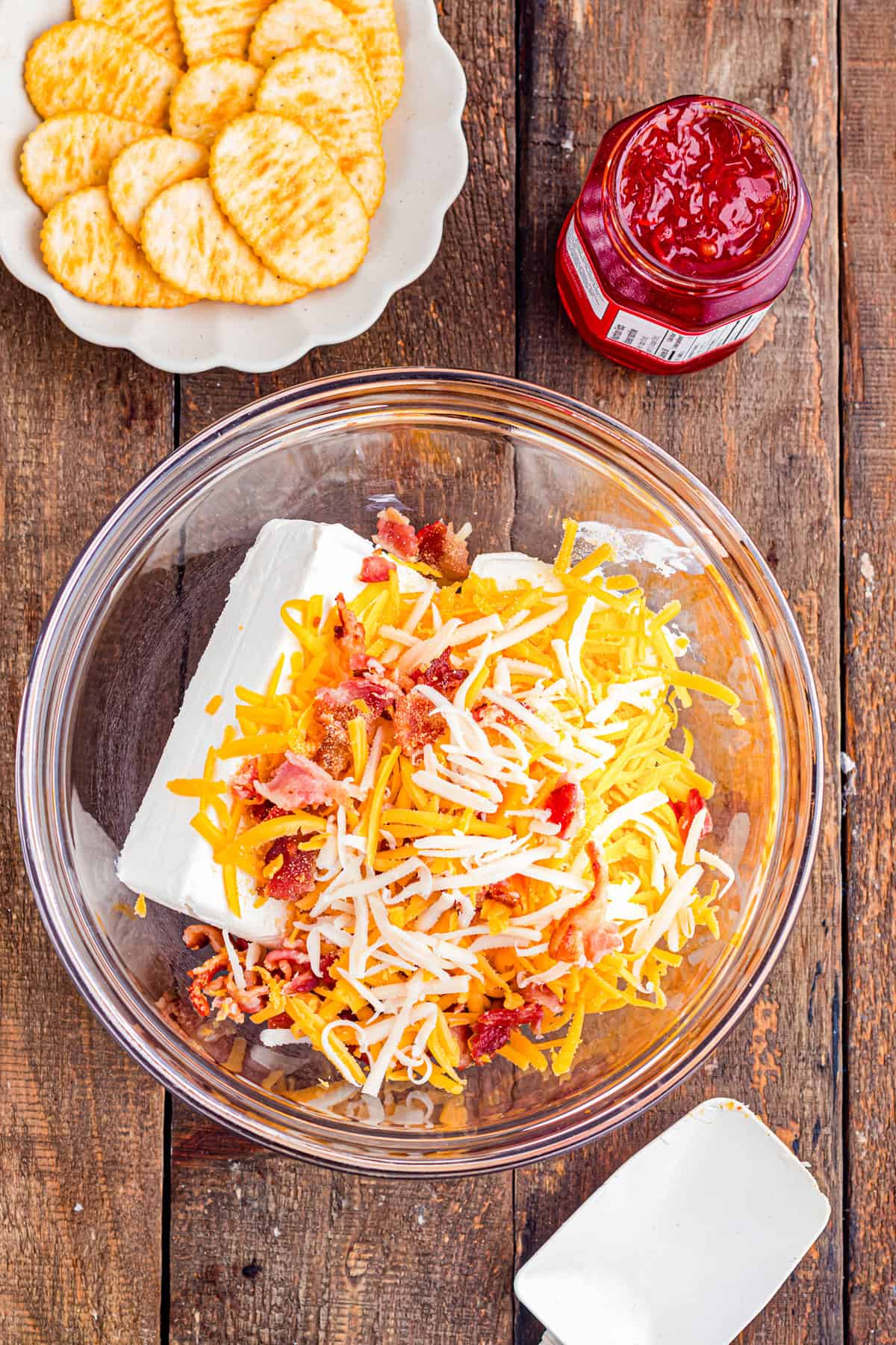Cream cheese, shredded cheese, and bacon in a dish