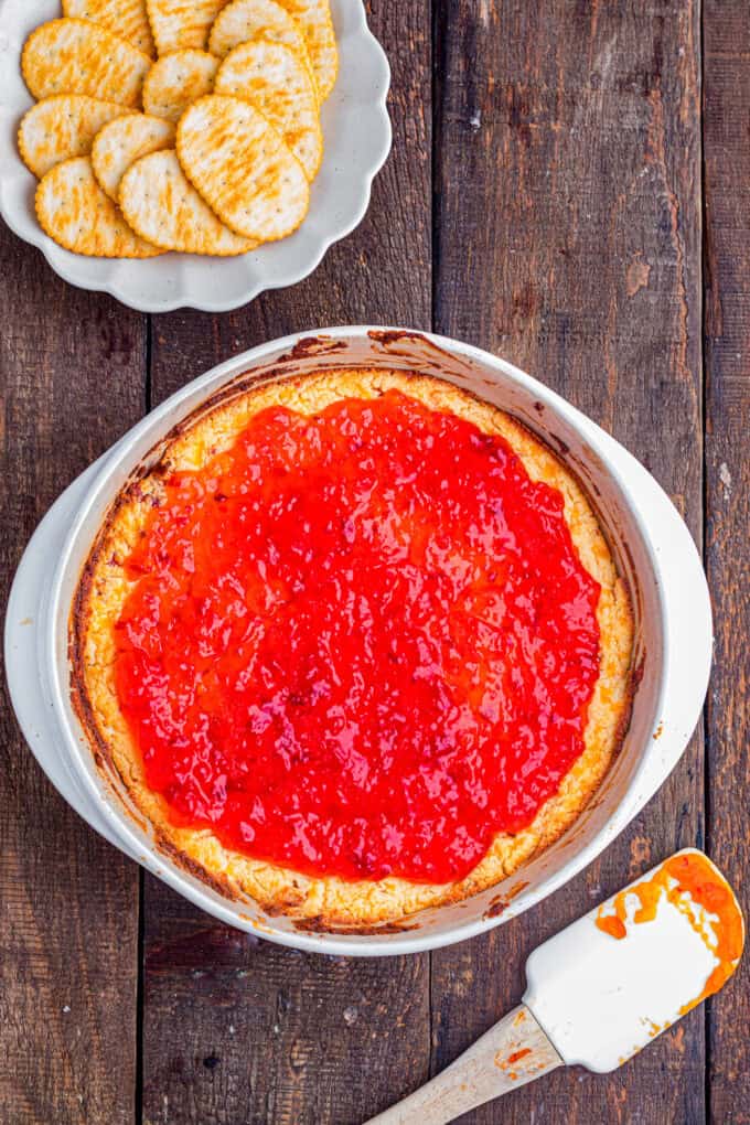 This easy Pepper Jelly Cream Cheese Dip is creamy, cheesy, smoky, and perfectly sweet and spicy! Perfect for holidays & game days. Overhead view of a baking dish of pepper jelly cream cheese dip