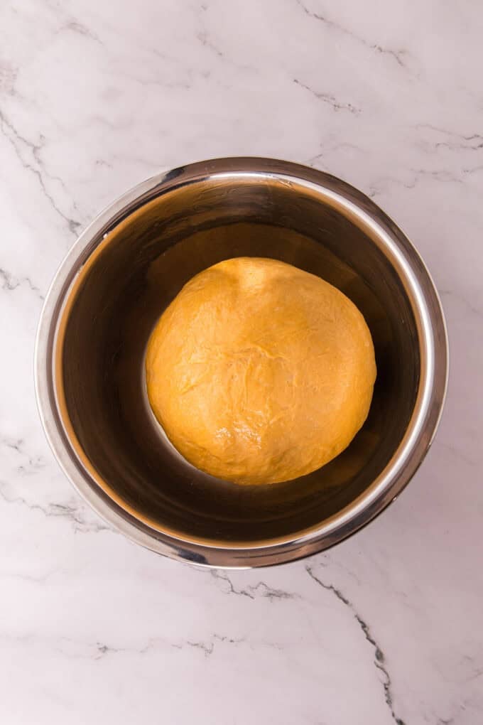 These soft, fluffy Sweet Potato Rolls are brushed with warm honey butter right out of the oven. Easy to make with a few basic ingredients! Sweet potato bread dough in a balll