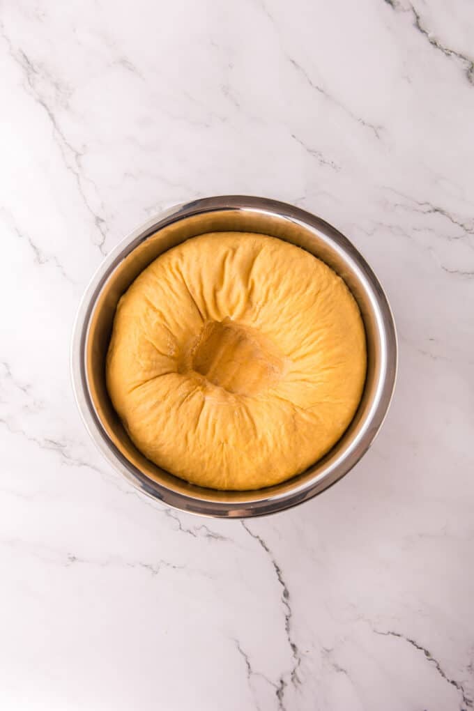These soft, fluffy Sweet Potato Rolls are brushed with warm honey butter right out of the oven. Easy to make with a few basic ingredients! Sweet potato roll dough punched down